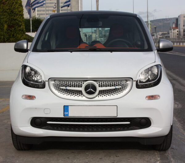 This is a white Smart Fortwo 453 with its front end tuned by Smart Power Design. It has installed the Front Grille, the Low Grill Trim piece and the Headlight Eyebrows.